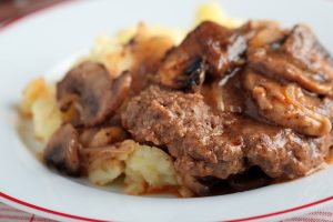 Salisbury steak with mashed potato under mushroom gravy